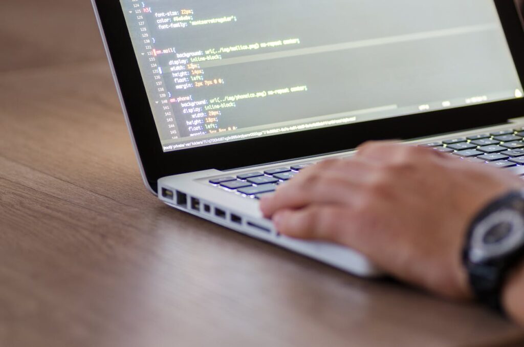 Person coding on a laptop building a Flutter ListView