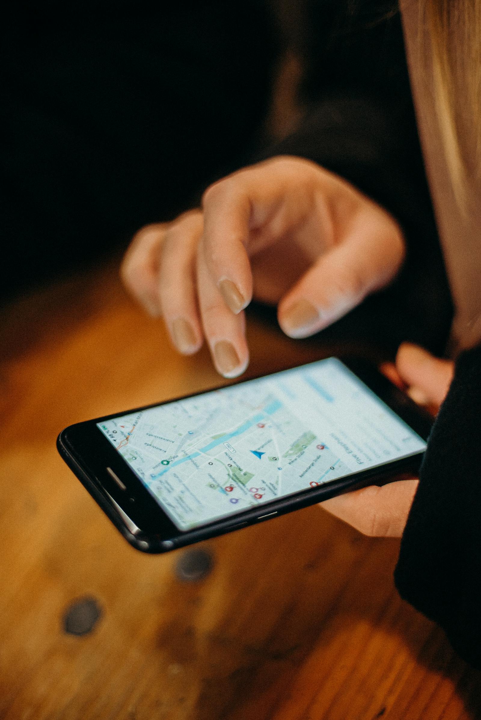 Hand holding a smartphone displaying a map application for navigation.