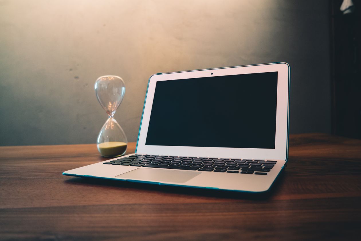 Laptop beside an hourglass representing a Dart Future in progress